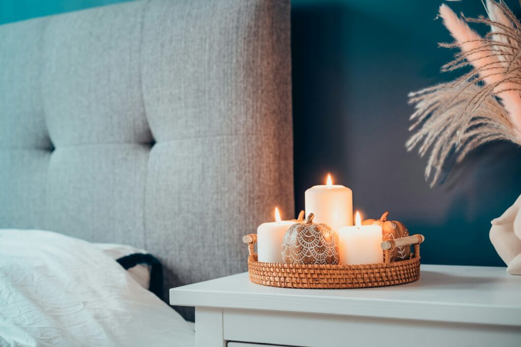Autumn decor in stylish modern bedroom. Cozy interior with dark emerald wall, grey fabric headboard
